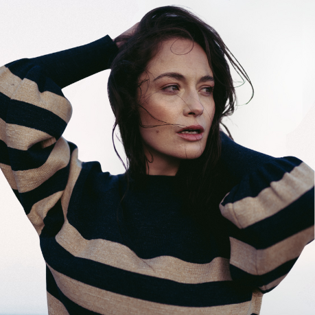 Woman wearing a black and beige striped sweater on a beach